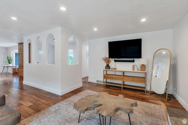 living area featuring baseboards, wood finished floors, recessed lighting, and plenty of natural light