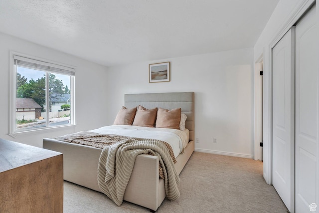 bedroom featuring light colored carpet and baseboards