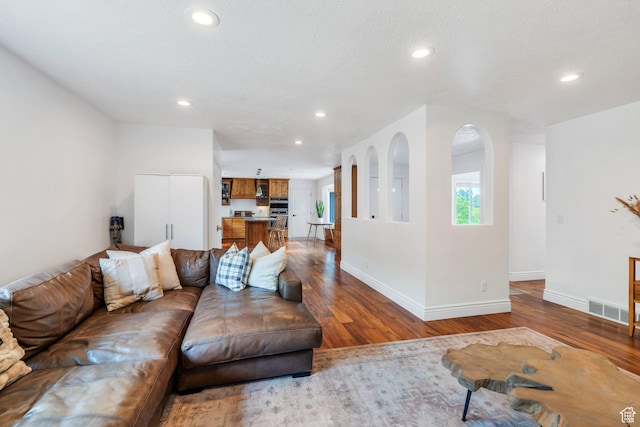living area with recessed lighting, wood finished floors, and baseboards