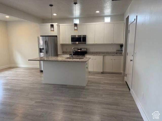 3586 S Xenon Dr, West Valley City, UT 84119 - kitchen with appliances with stainless steel finishes, a sink, baseboards, wood finished floors, and white cabinetry