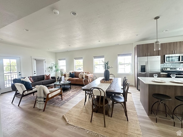 7838 S Holden St, Midvale, UT 84047 - dining space featuring light wood-style flooring, a textured ceiling, healthy amount of natural light, and recessed lighting