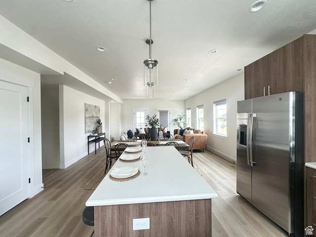 7838 S Holden St, Midvale, UT 84047 - kitchen featuring stainless steel fridge with ice dispenser, light countertops, light wood-style flooring, and recessed lighting