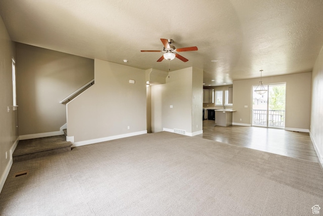 972 S High Ridge Rd, Spanish Fork, UT 84660 - unfurnished living room with light carpet, a ceiling fan, baseboards, and stairway
