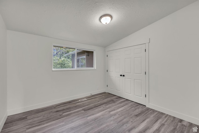770 W 550 N, Clearfield, UT 84015 - unfurnished bedroom featuring lofted ceiling, a textured ceiling, wood finished floors, baseboards, and a closet