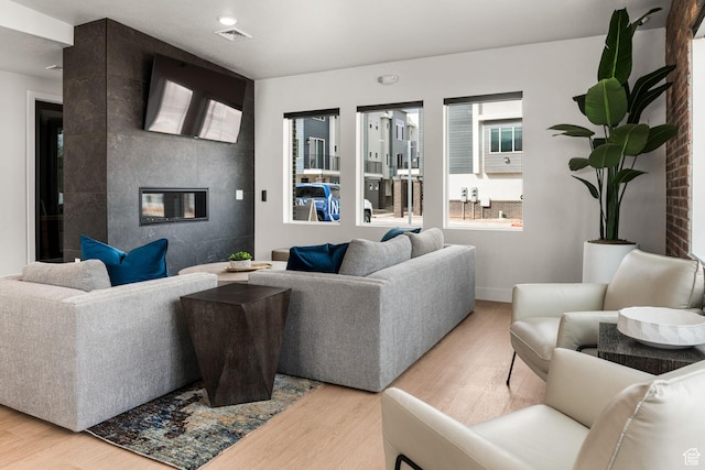 2336 W James Way Unit J34, West Haven, UT 84401 - living area featuring light wood finished floors, a fireplace, and baseboards