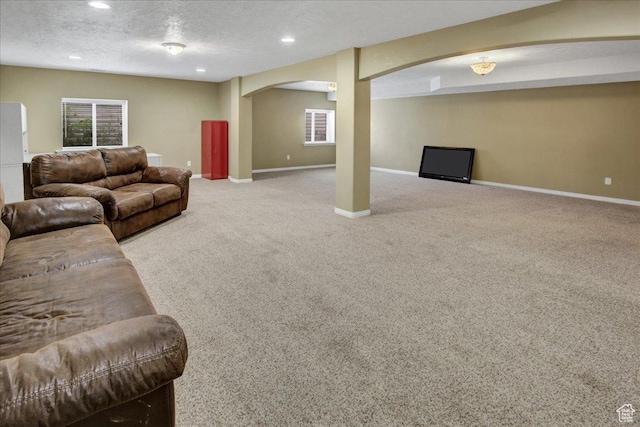 living area with arched walkways, carpet flooring, baseboards, recessed lighting, and a textured ceiling
