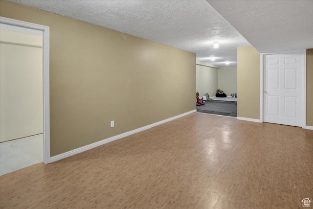finished basement with wood finished floors, baseboards, and a textured ceiling