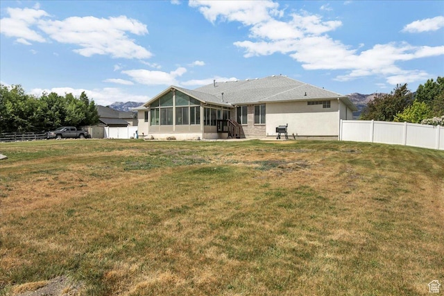 back of house with a sunroom, stucco siding, and a shed