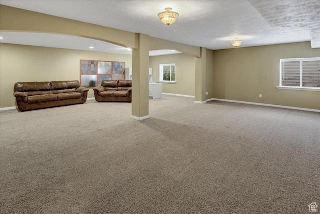 carpeted living room featuring arched walkways and baseboards