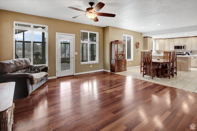 living area featuring a ceiling fan, light wood-style flooring, baseboards, and recessed lighting
