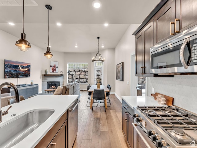 909 W Peace Tree Trl W Unit 416, Heber City, UT 84032 - kitchen with appliances with stainless steel finishes, a sink, light wood-type flooring, pendant lighting, and recessed lighting