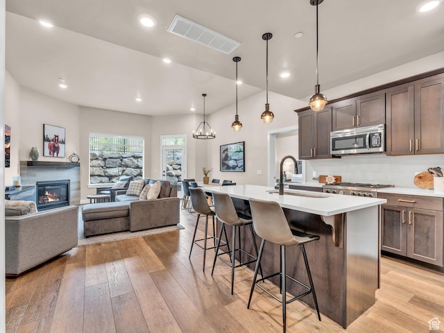 909 W Peace Tree Trl W Unit 416, Heber City, UT 84032 - kitchen featuring stainless steel microwave, a sink, a kitchen breakfast bar, open floor plan, and a kitchen island with sink