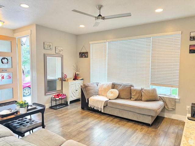 living room featuring a ceiling fan, hardwood / wood-style flooring, recessed lighting, and plenty of natural light
