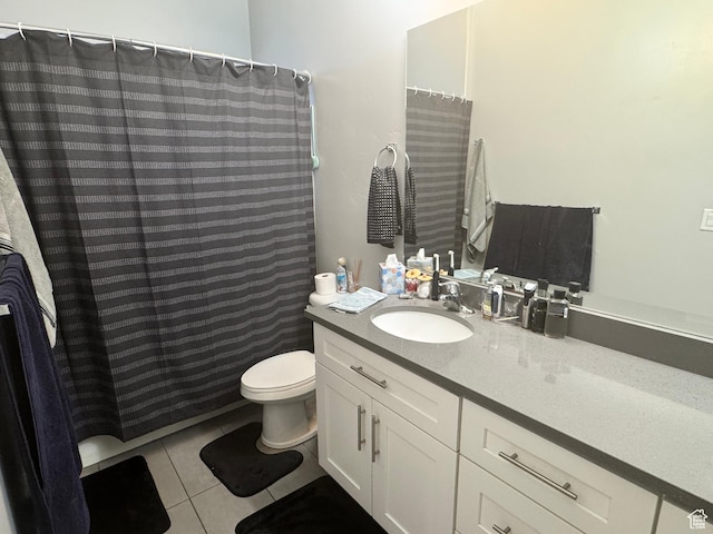 bathroom with tile patterned flooring, toilet, vanity, and curtained shower