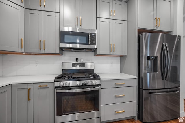 6613 S Ellerston Dr W, Murray, UT 84123 - kitchen featuring appliances with stainless steel finishes, gray cabinets, light countertops, and decorative backsplash