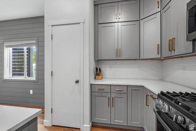 6613 S Ellerston Dr W, Murray, UT 84123 - kitchen with gray cabinetry, light countertops, decorative backsplash, and stainless steel appliances