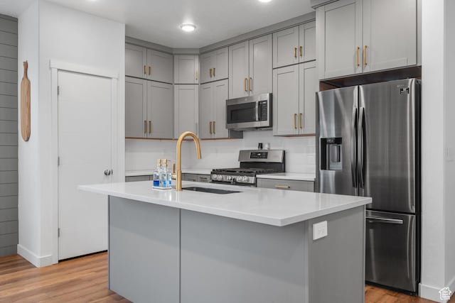6613 S Ellerston Dr W, Murray, UT 84123 - kitchen with appliances with stainless steel finishes, a sink, gray cabinetry, light wood-type flooring, and light countertops
