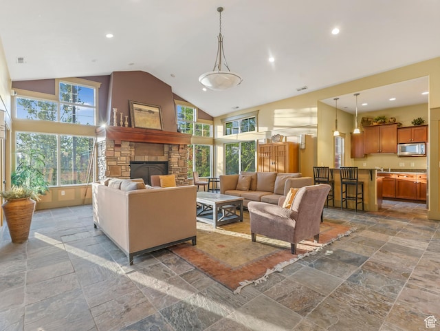 14910 S Ox Cart Ln, Draper, UT 84020 - living room featuring stone tile flooring, high vaulted ceiling, a stone fireplace, plenty of natural light, and recessed lighting