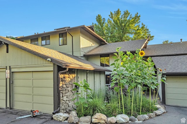 4604 S Woodduck Ln, Millcreek, UT 84117 - view of front of house featuring a shingled roof, a garage, and stone siding
