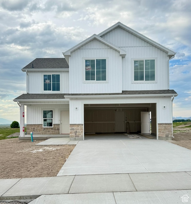 243 W 730 N, Smithfield, UT 84335 - view of front facade featuring stone siding, driveway, a garage, roof with shingles, and covered porch