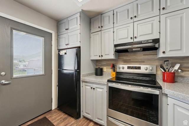 kitchen with freestanding refrigerator, stainless steel electric range oven, under cabinet range hood, and light countertops