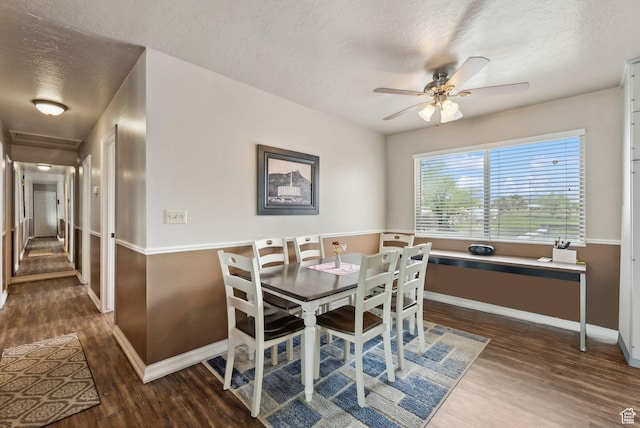 dining room featuring wood finished floors, baseboards, a textured ceiling, and ceiling fan