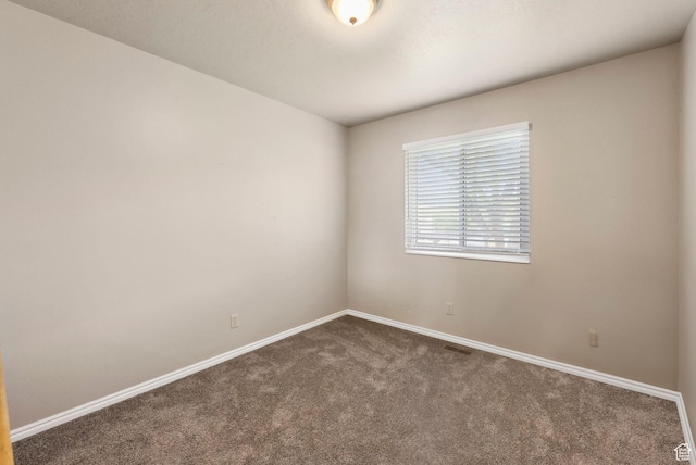 carpeted spare room with baseboards