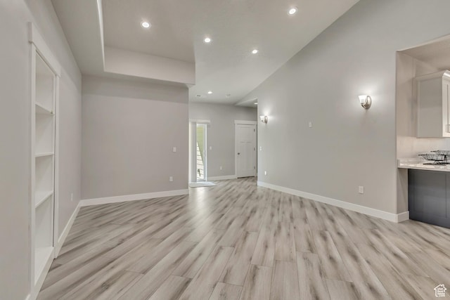 unfurnished living room featuring recessed lighting, light wood-style floors, and baseboards