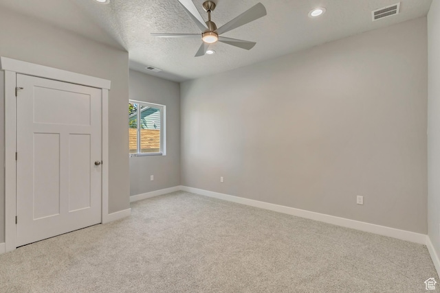 spare room featuring light colored carpet, baseboards, a ceiling fan, a textured ceiling, and recessed lighting