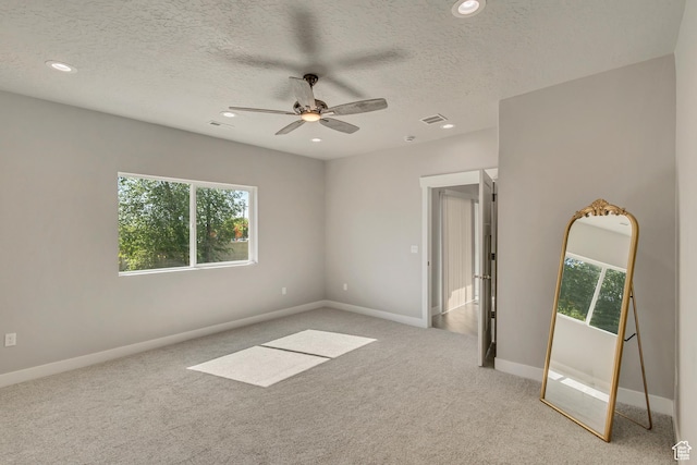 carpeted empty room with plenty of natural light, ceiling fan, recessed lighting, a textured ceiling, and baseboards
