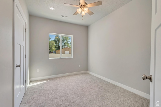 unfurnished bedroom featuring carpet floors, a textured ceiling, baseboards, and a ceiling fan