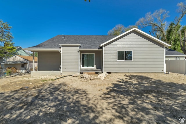 view of front of home with fence and roof with shingles