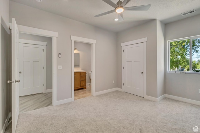 unfurnished bedroom with light colored carpet, baseboards, connected bathroom, and recessed lighting