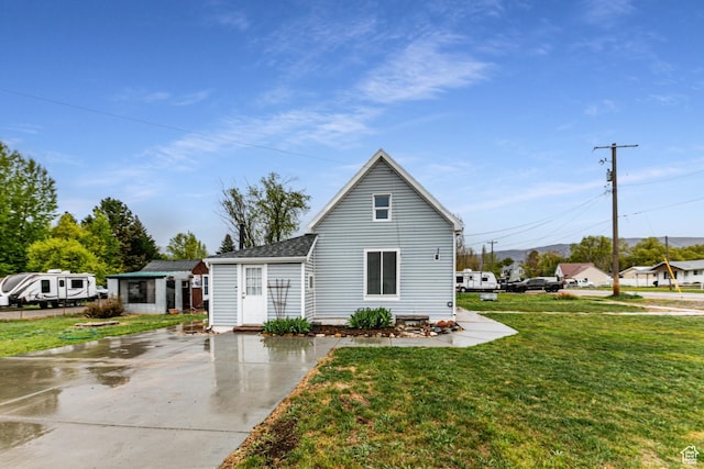 view of front of house with a front lawn and a shingled roof