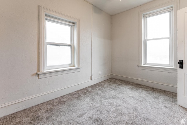 carpeted empty room featuring healthy amount of natural light