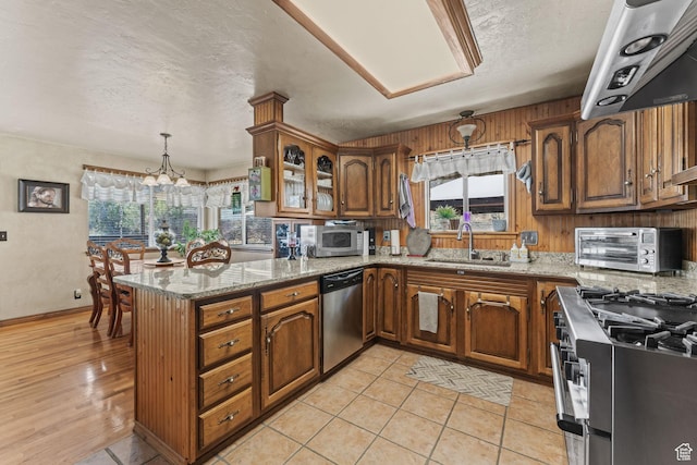 6407 N Dry Fork Cyn W, Dry Fork, UT 84078 - kitchen with stainless steel appliances, brown cabinets, a sink, a peninsula, and a textured ceiling