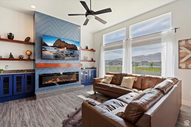 5118 N Blackbrush Dr, Eagle Mountain, UT 84005 - living area featuring a large fireplace, ceiling fan, wood finished floors, built in features, and baseboards