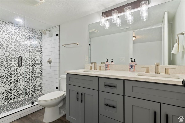 5118 N Blackbrush Dr, Eagle Mountain, UT 84005 - bathroom featuring baseboard heating, toilet, a textured ceiling, tiled shower, and double vanity
