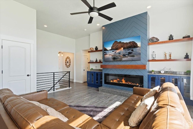 5118 N Blackbrush Dr, Eagle Mountain, UT 84005 - living room featuring ceiling fan, wood finished floors, a large fireplace, recessed lighting, and a towering ceiling