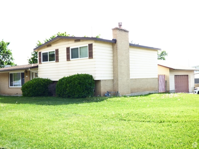 648 S 1350 E, Provo, UT 84606 - view of side of property with a chimney, brick siding, a lawn, and a garage