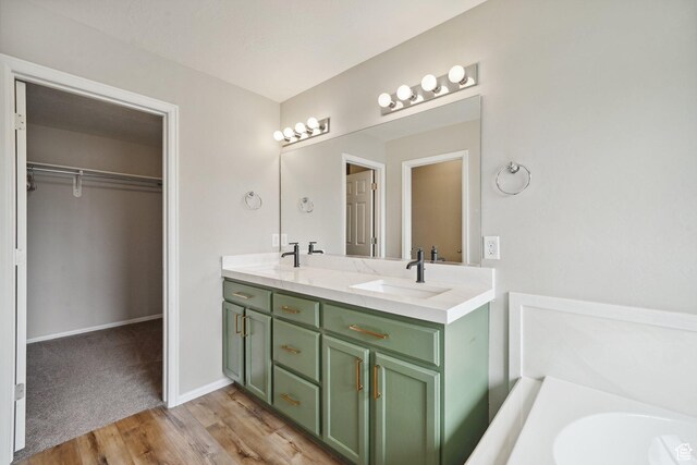 1805 W Grays Pl N, Lehi, UT 84043 - bathroom with wood finished floors, double vanity, a walk in closet, a bath, and baseboards