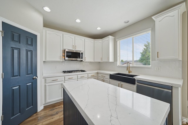 1805 W Grays Pl N, Lehi, UT 84043 - kitchen with stainless steel appliances, a sink, wood finished floors, white cabinetry, and light stone counters