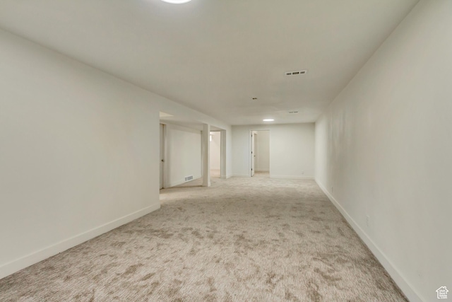 unfurnished room with light carpet and baseboards
