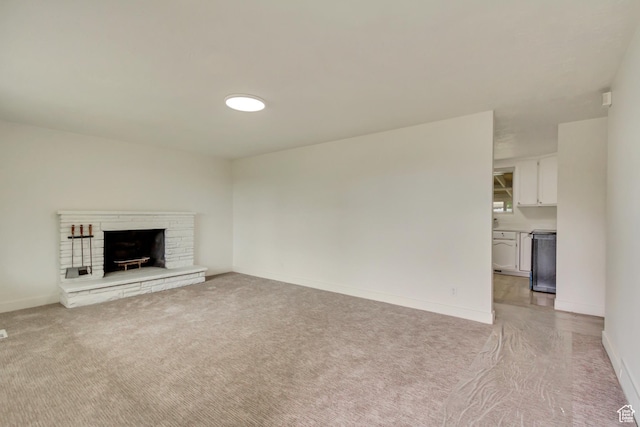 unfurnished living room with light colored carpet, baseboards, and a fireplace