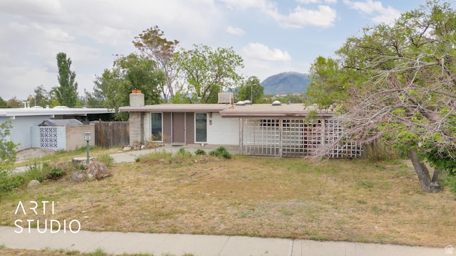 941 E Carnation Dr, Sandy, UT 84094 - view of front of home featuring a chimney, fence, and a mountain view
