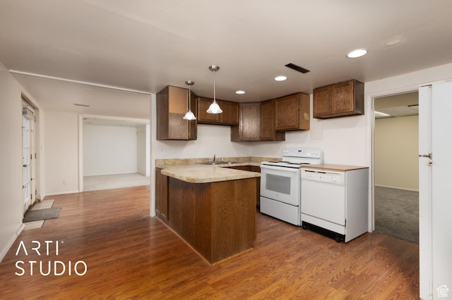 941 E Carnation Dr, Sandy, UT 84094 - kitchen featuring white appliances, a peninsula, light countertops, a sink, and dark wood-type flooring