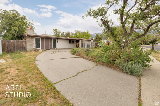 941 E Carnation Dr, Sandy, UT 84094 - view of front of house featuring driveway, fence, and a chimney