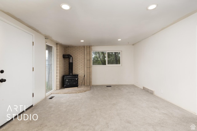 941 E Carnation Dr, Sandy, UT 84094 - unfurnished living room featuring a wood stove, carpet floors, and recessed lighting