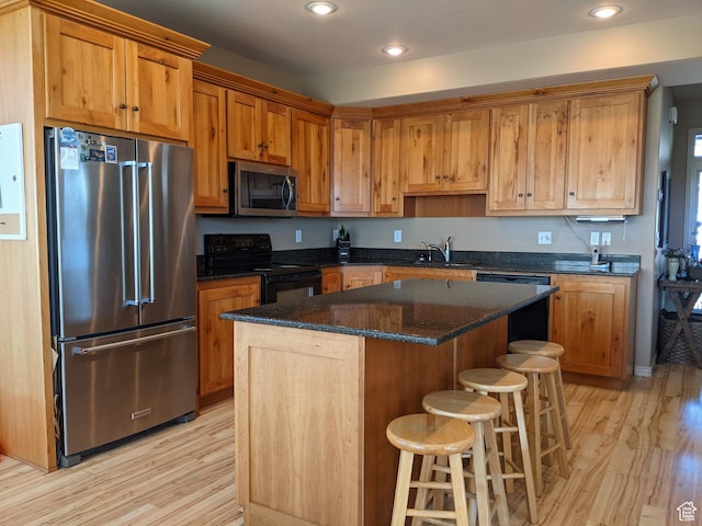 465 N 100th St E, Millville, UT 84326 - kitchen featuring black appliances, light wood finished floors, a breakfast bar, a center island, and recessed lighting