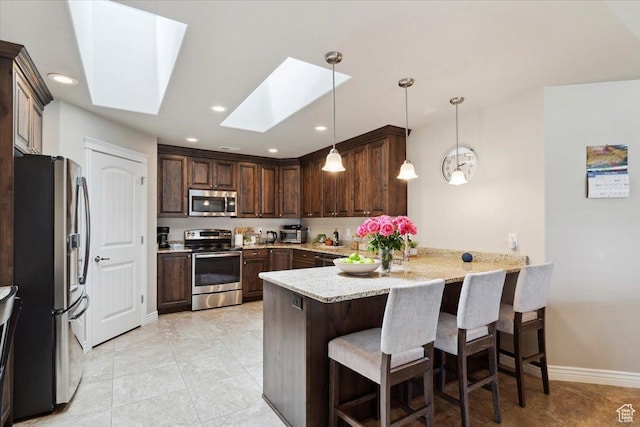 1776 W 3025 S, Syracuse, UT 84075 - kitchen featuring stainless steel appliances, a peninsula, a skylight, dark brown cabinetry, and a kitchen bar